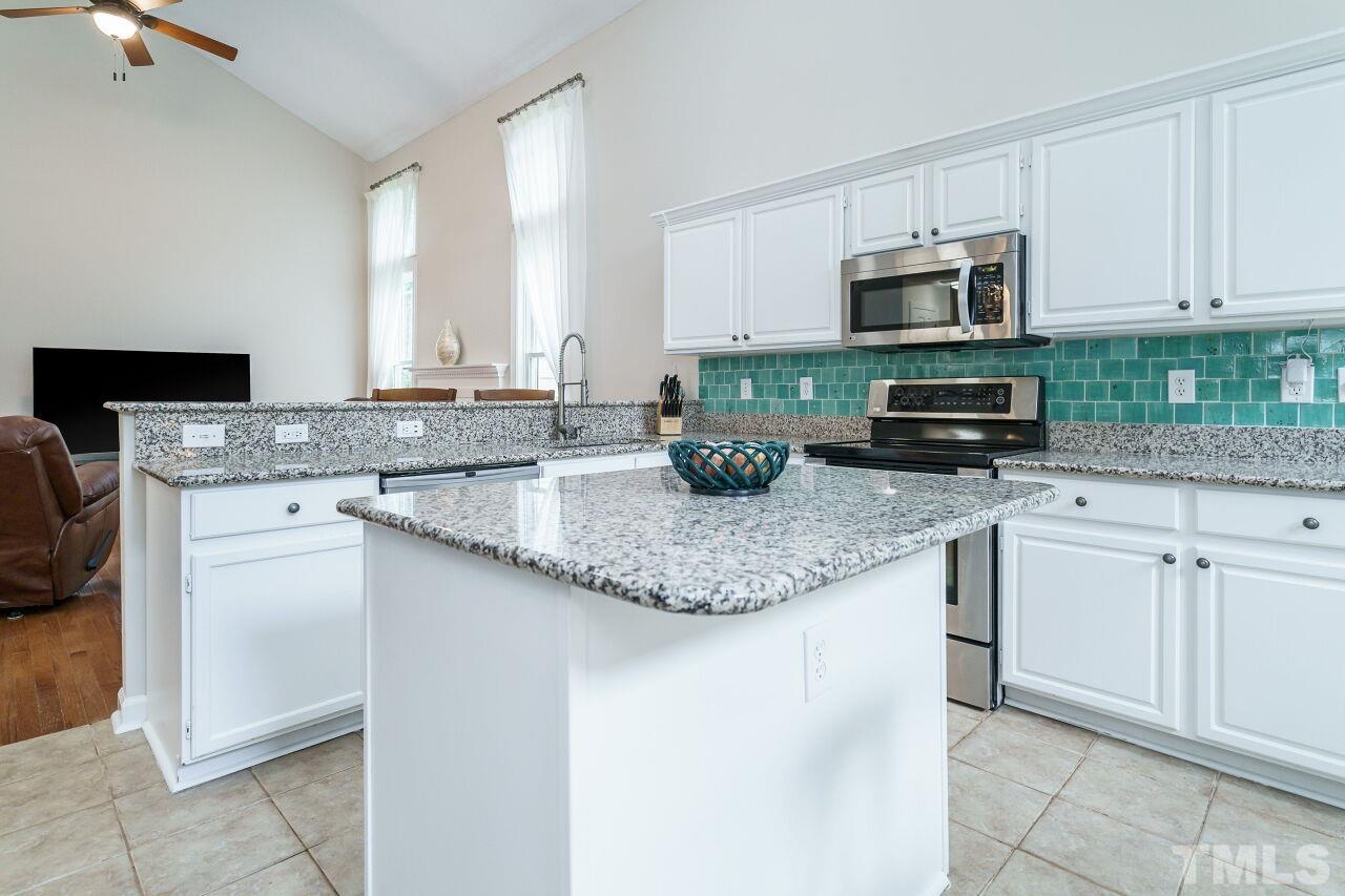 206 Firetree Lane Cary, NC 27513 - Photo 12 of 44 a kitchen with stainless steel appliances granite countertop a sink and a stove
