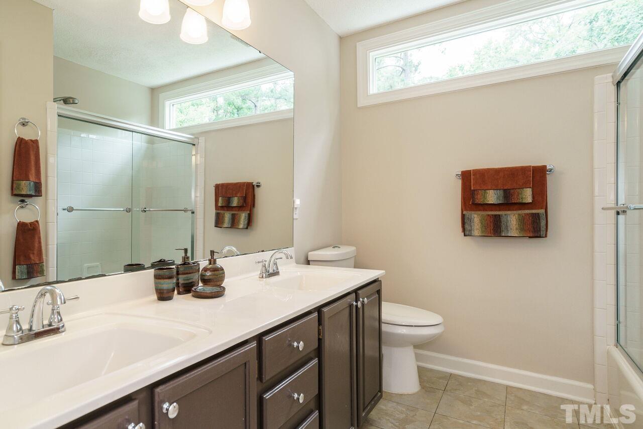 206 Firetree Lane Cary, NC 27513 - Photo 21 of 44 a bathroom with a sink a toilet and mirror