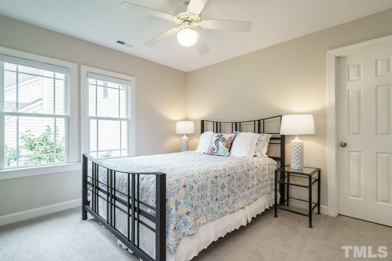 206 Firetree Lane Cary, NC 27513 - Photo 22 of 44 a bedroom with a bed and a chandelier