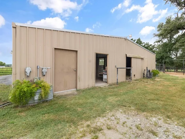 a view of a house with a backyard and a large tree