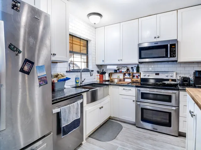 a kitchen with stainless steel appliances granite countertop a refrigerator sink and microwave
