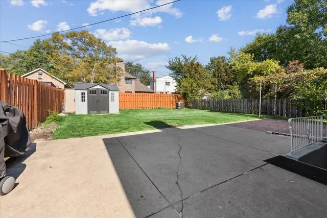 a view of a backyard with brick wall and plants