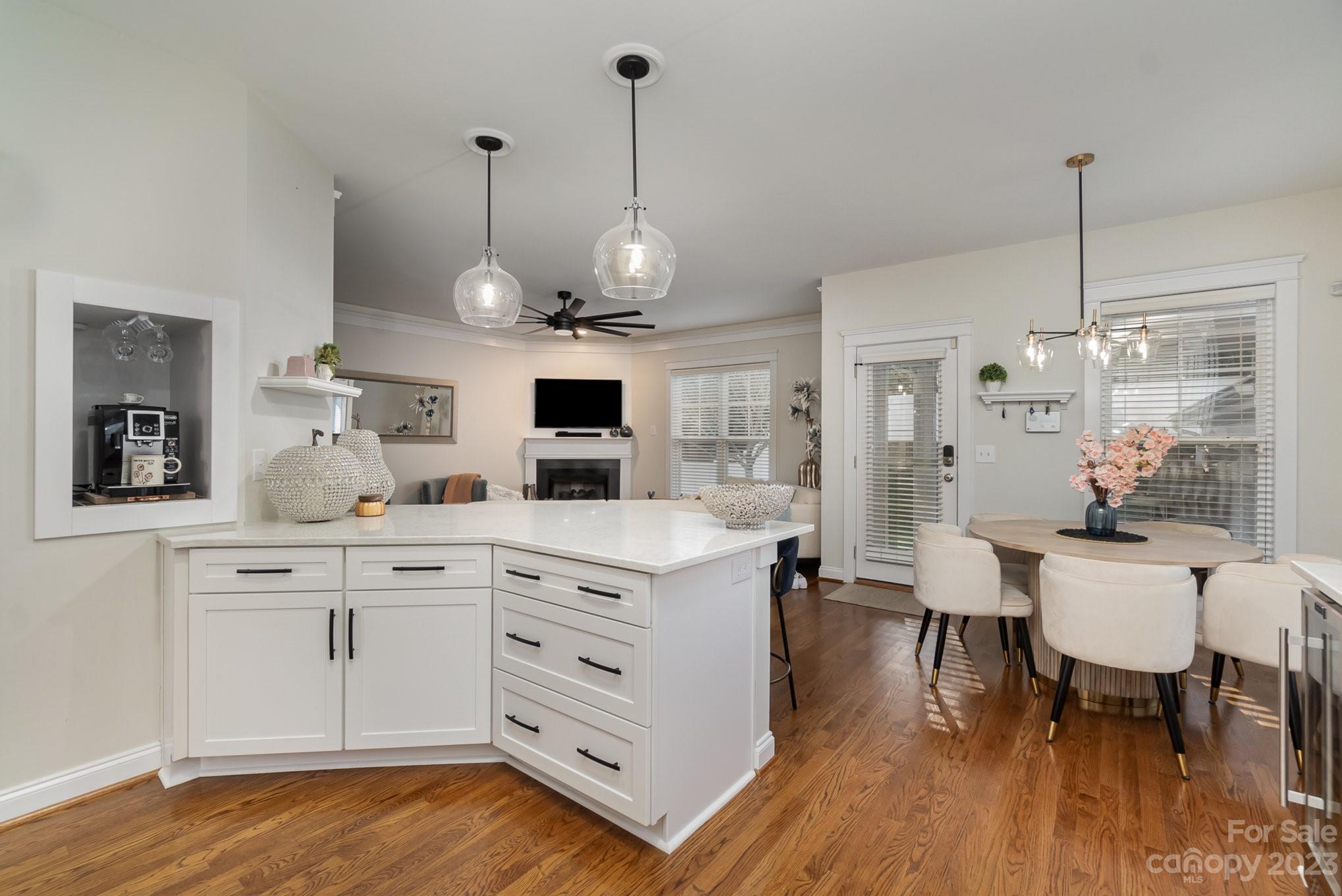 8128 Townley Road Huntersville, NC 28078 - Photo 8 of 20 a open kitchen with stainless steel appliances granite countertop a dishwasher a stove a dining table chairs and couches with wooden floor