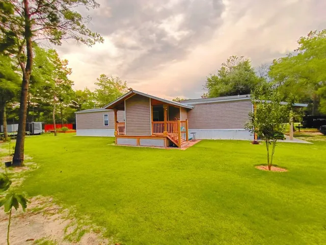 a front view of house with garden and trees