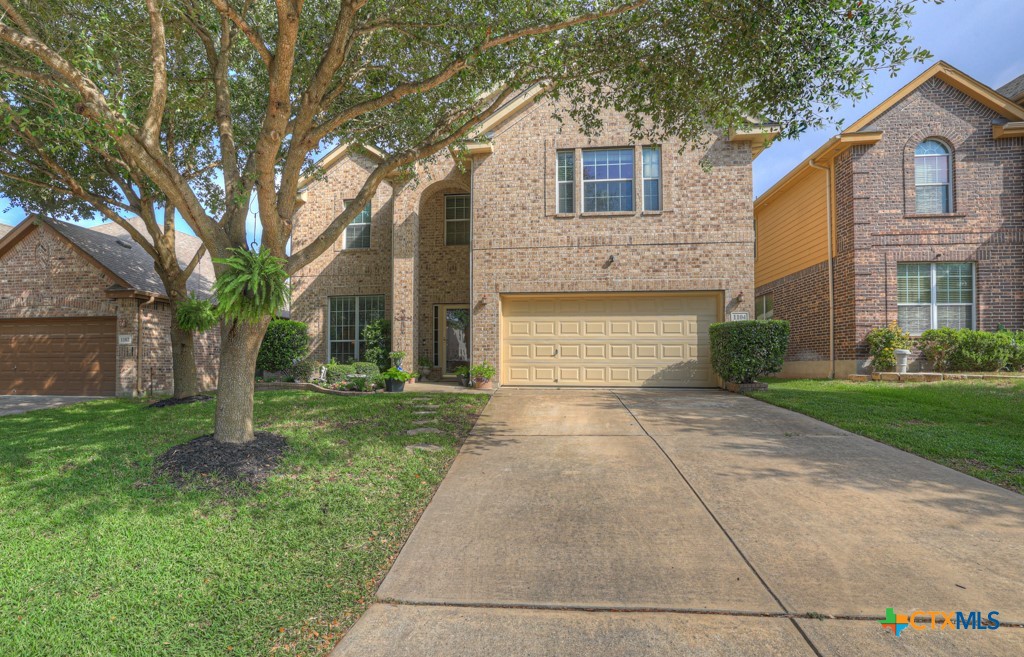 a front view of a house with a yard and trees