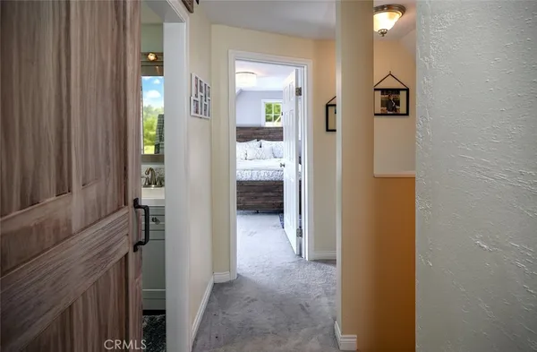 a view of a hallway with wooden floor and living room