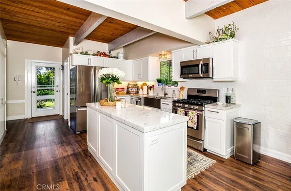 a open kitchen with stainless steel appliances granite countertop a stove and a refrigerator