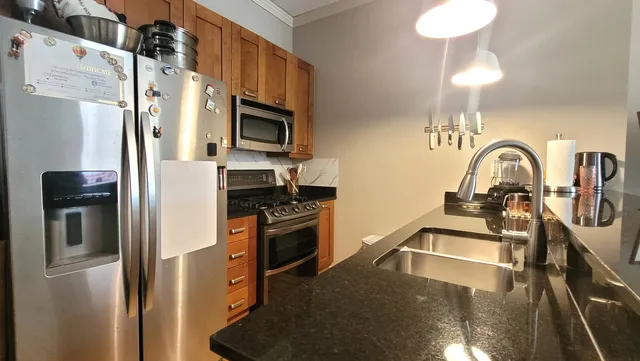 a kitchen with stainless steel appliances a refrigerator sink and microwave