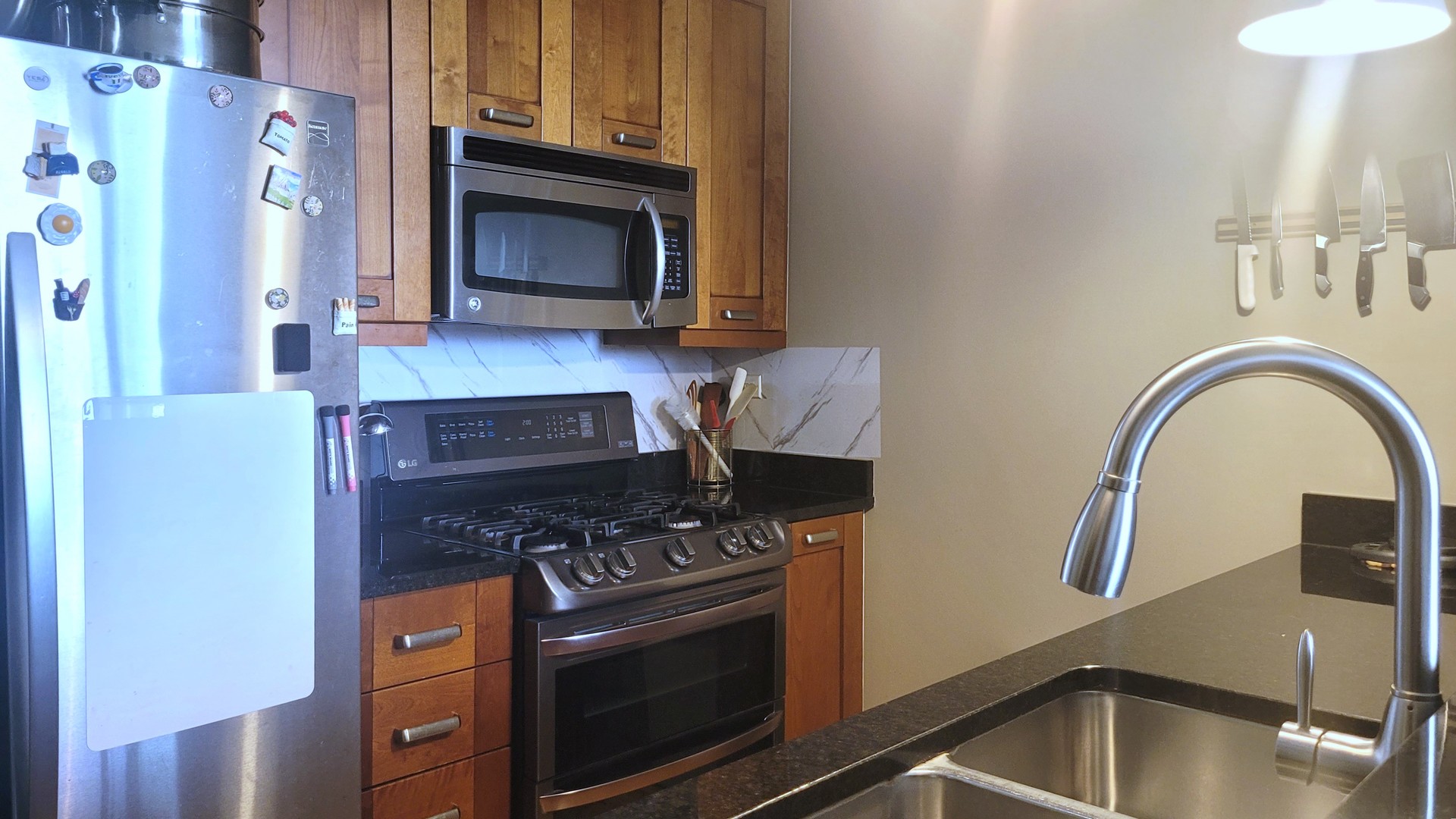 170 West Polk Street, Unit 1003 Chicago, IL 60605 - Photo 9 of 27 a kitchen with granite countertop a stove and a microwave