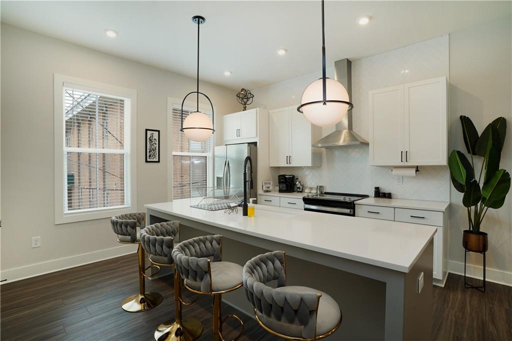 154 Chestnut Circle, Unit 80 Atlanta, GA 30342 - Photo 3 of 31 a kitchen with stainless steel appliances granite countertop a stove a sink dishwasher a dining table and chairs with wooden floor