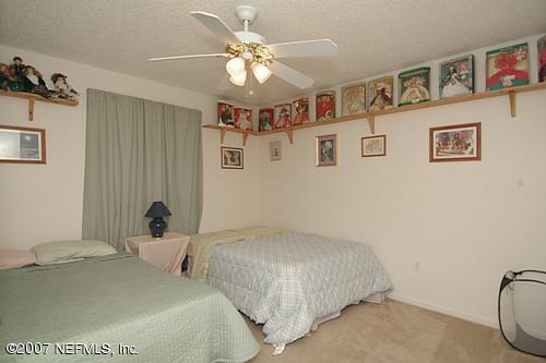703 Cherry Street Neptune Beach, FL 32266 - Photo 11 of 15 a bedroom with a bed and a chandelier