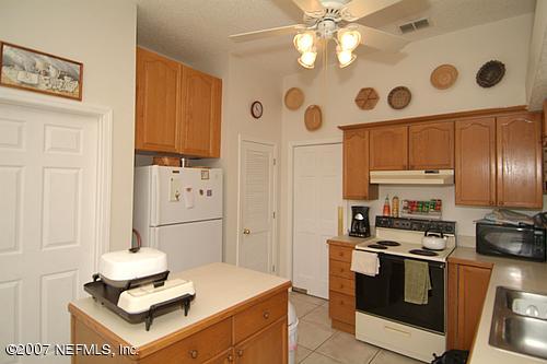 703 Cherry Street Neptune Beach, FL 32266 - Photo 4 of 15 a kitchen with stainless steel appliances granite countertop a stove and a refrigerator with white cabinets