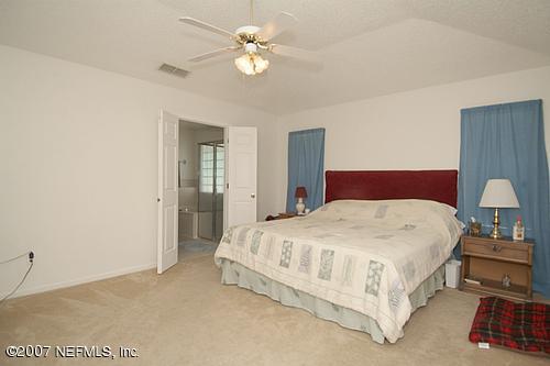 703 Cherry Street Neptune Beach, FL 32266 - Photo 7 of 15 a spacious bedroom with a bed and a chandelier