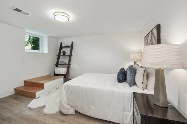 a bedroom with a bed and wooden floor