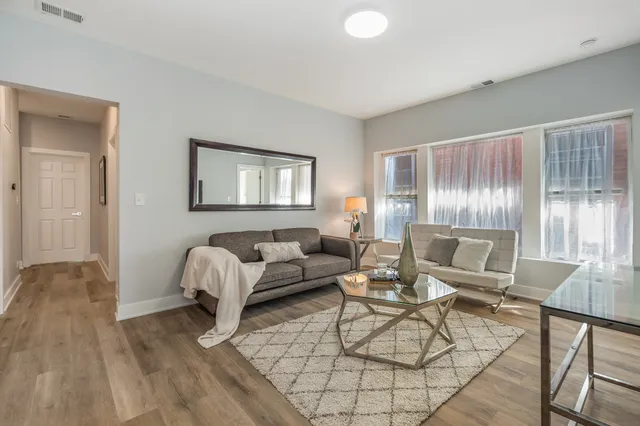a living room with furniture and wooden floor