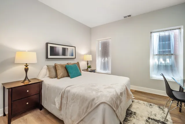 a bedroom with a bed and a lamp on table