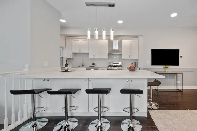 a kitchen with a dining table chairs and white cabinets