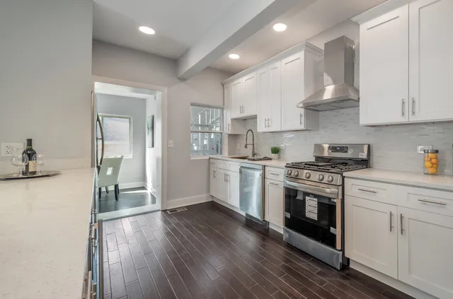 a kitchen with granite countertop white cabinets and white appliances