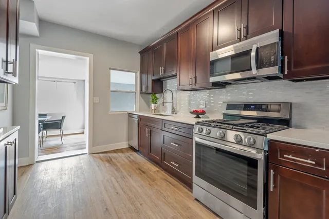 a kitchen with stainless steel appliances wooden cabinets and a stove top oven
