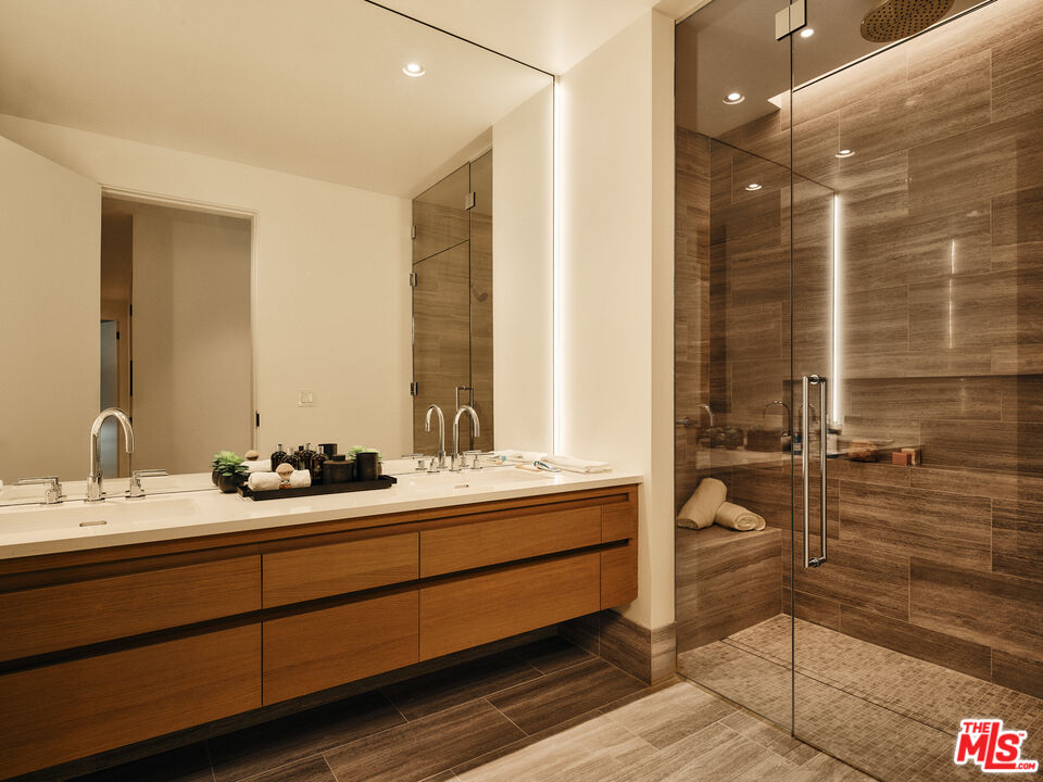 8899 Beverly Boulevard, Unit 8C Los Angeles, CA 90048 - Photo 16 of 33 a bathroom with a double vanity sink a mirror and shower