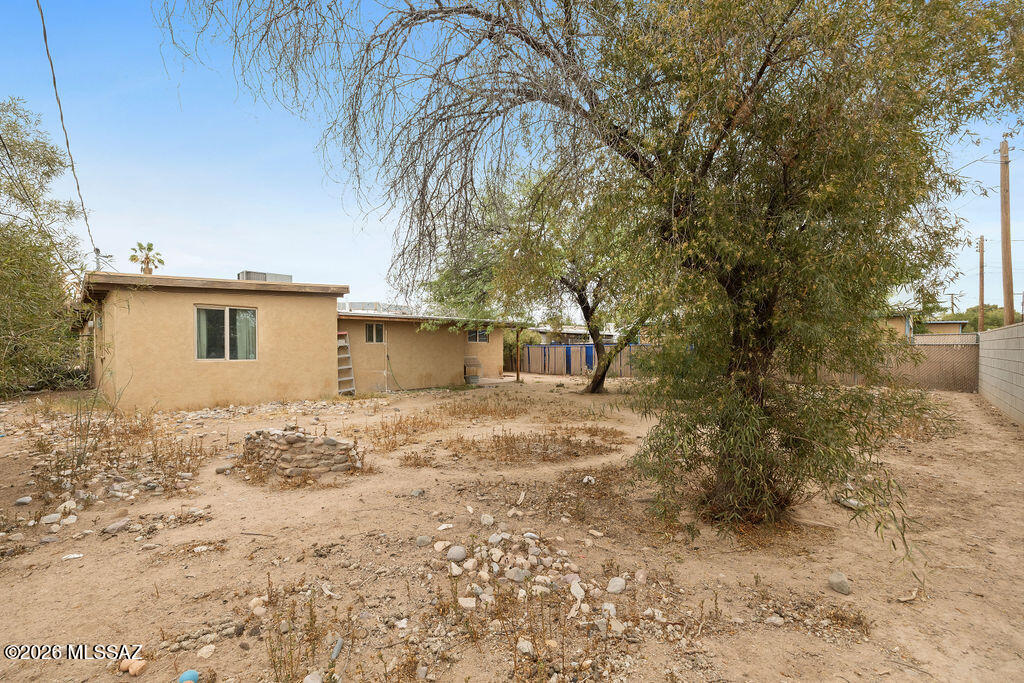 1301 West Kleindale Road Tucson, AZ 85705 - Photo 26 of 27 a backyard of a house with large trees and covered with wooden fence