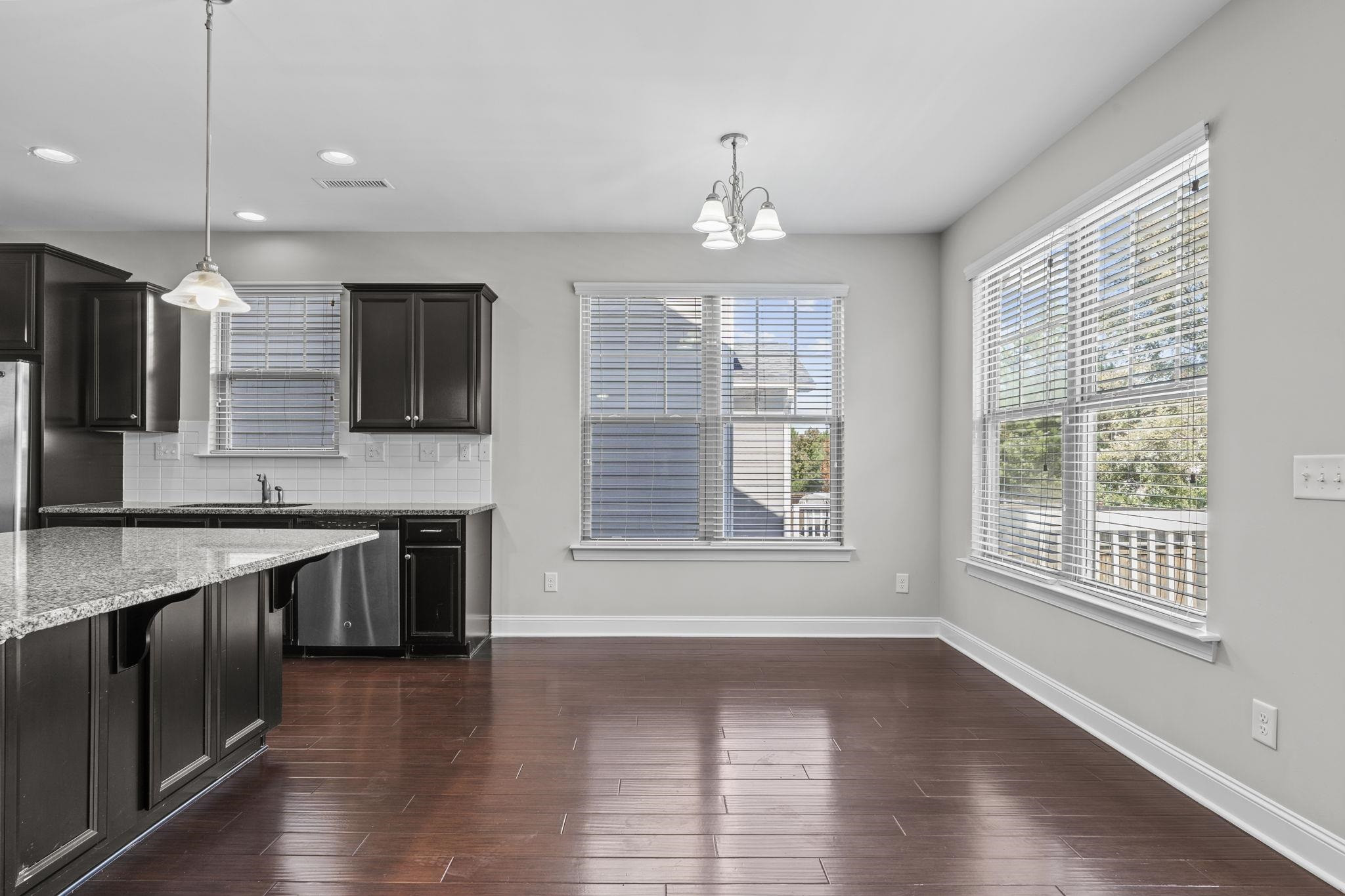 4240 Rockdell Hall Street Raleigh, NC 27616 - Photo 13 of 39 a large kitchen with stainless steel appliances granite countertop a stove and a wooden floors