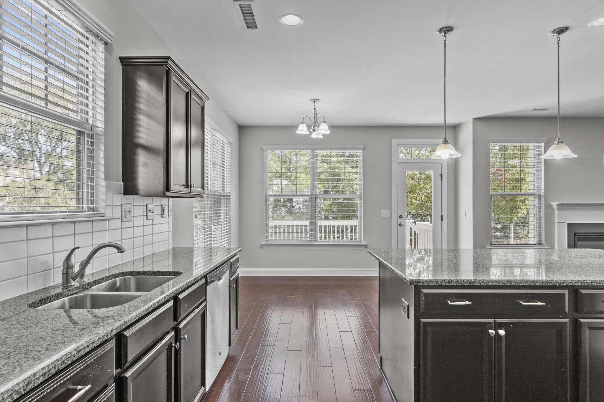 4240 Rockdell Hall Street Raleigh, NC 27616 - Photo 17 of 39 a kitchen with stainless steel appliances granite countertop a sink a stove and wooden floor