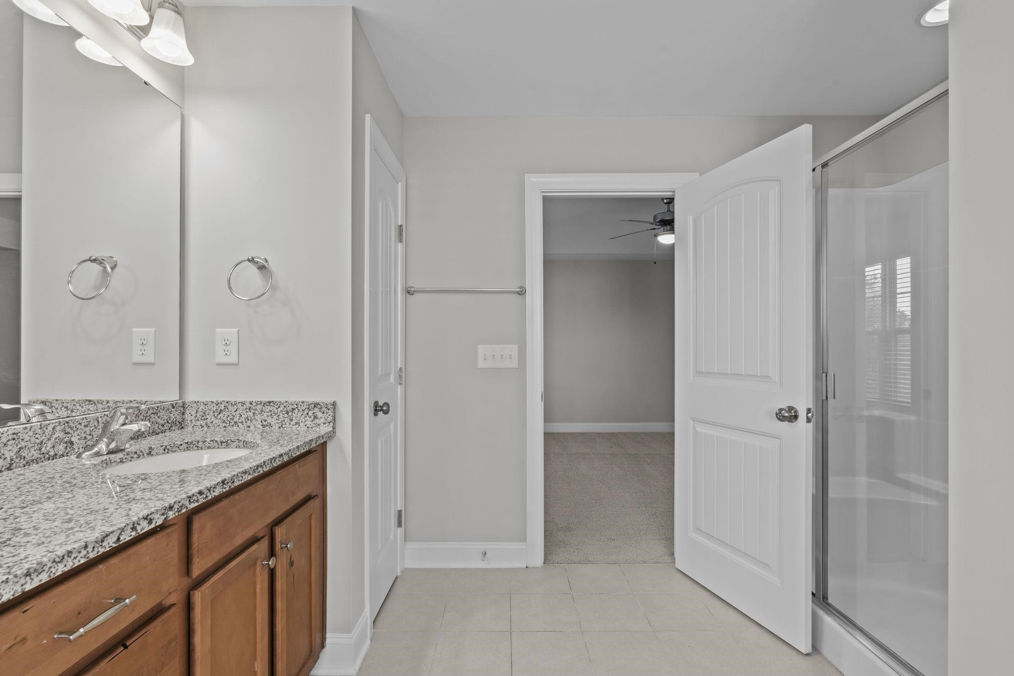 4240 Rockdell Hall Street Raleigh, NC 27616 - Photo 35 of 39 a bathroom with a granite countertop sink two mirror and shower