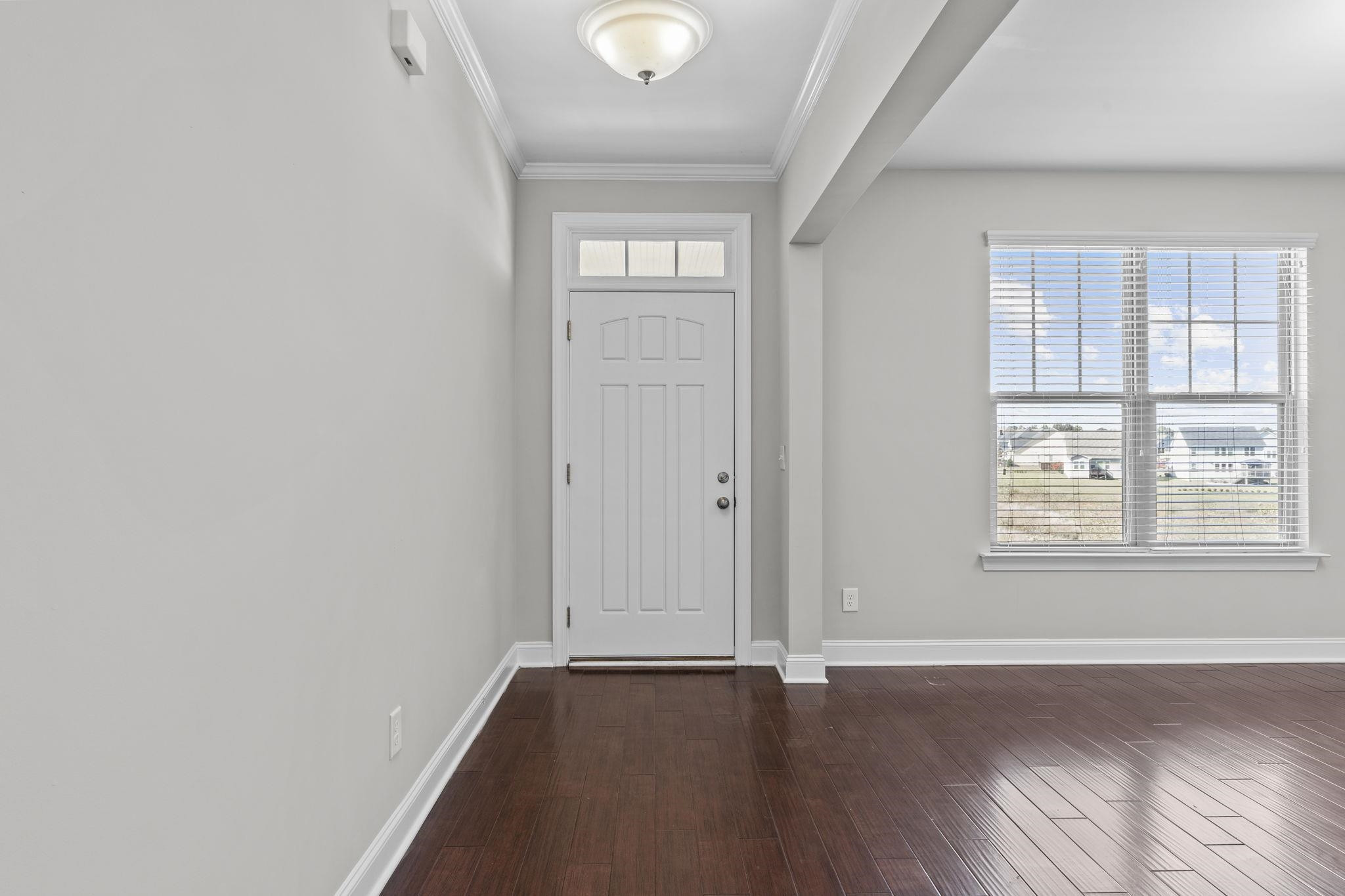 4240 Rockdell Hall Street Raleigh, NC 27616 - Photo 5 of 39 an empty room with wooden floor and windows