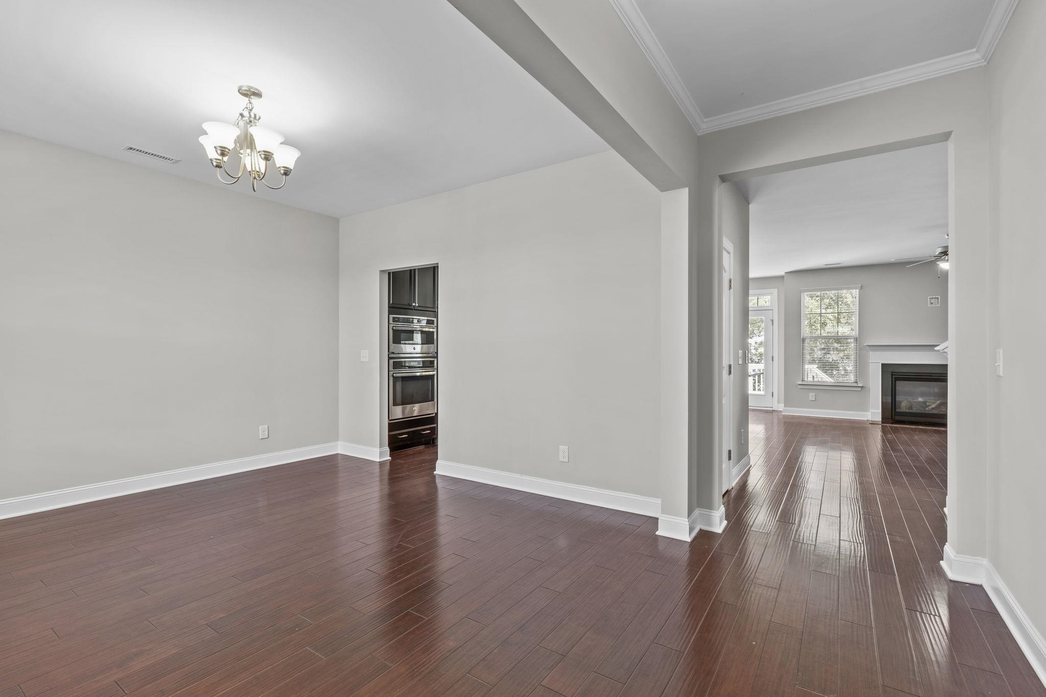 4240 Rockdell Hall Street Raleigh, NC 27616 - Photo 6 of 39 a view of an empty room with a chandelier and wooden floor