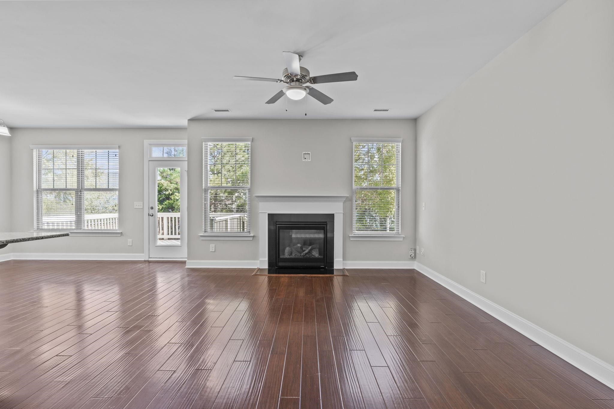 4240 Rockdell Hall Street Raleigh, NC 27616 - Photo 10 of 39 an empty room with wooden floor fireplace and windows