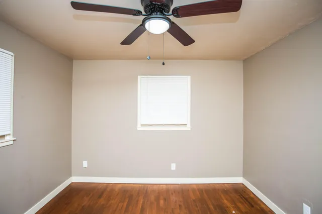 a view of room with hardwood floor and ceiling fan