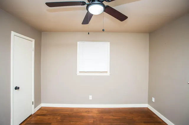 an empty room with fan and windows