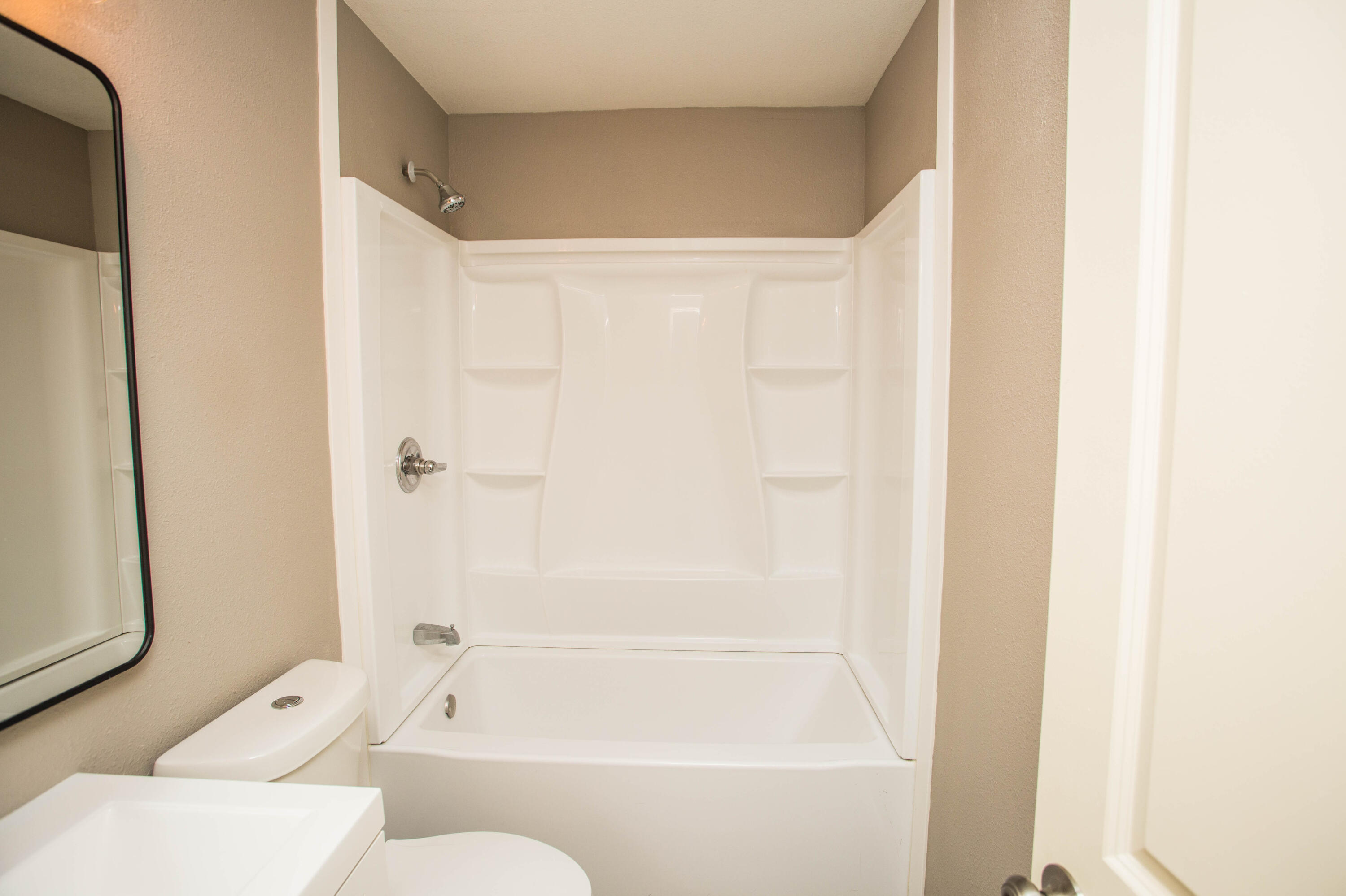 4402 29th Street, Unit B Lubbock, TX 79410 - Photo 17 of 23 a bathroom with a bathtub and a shower