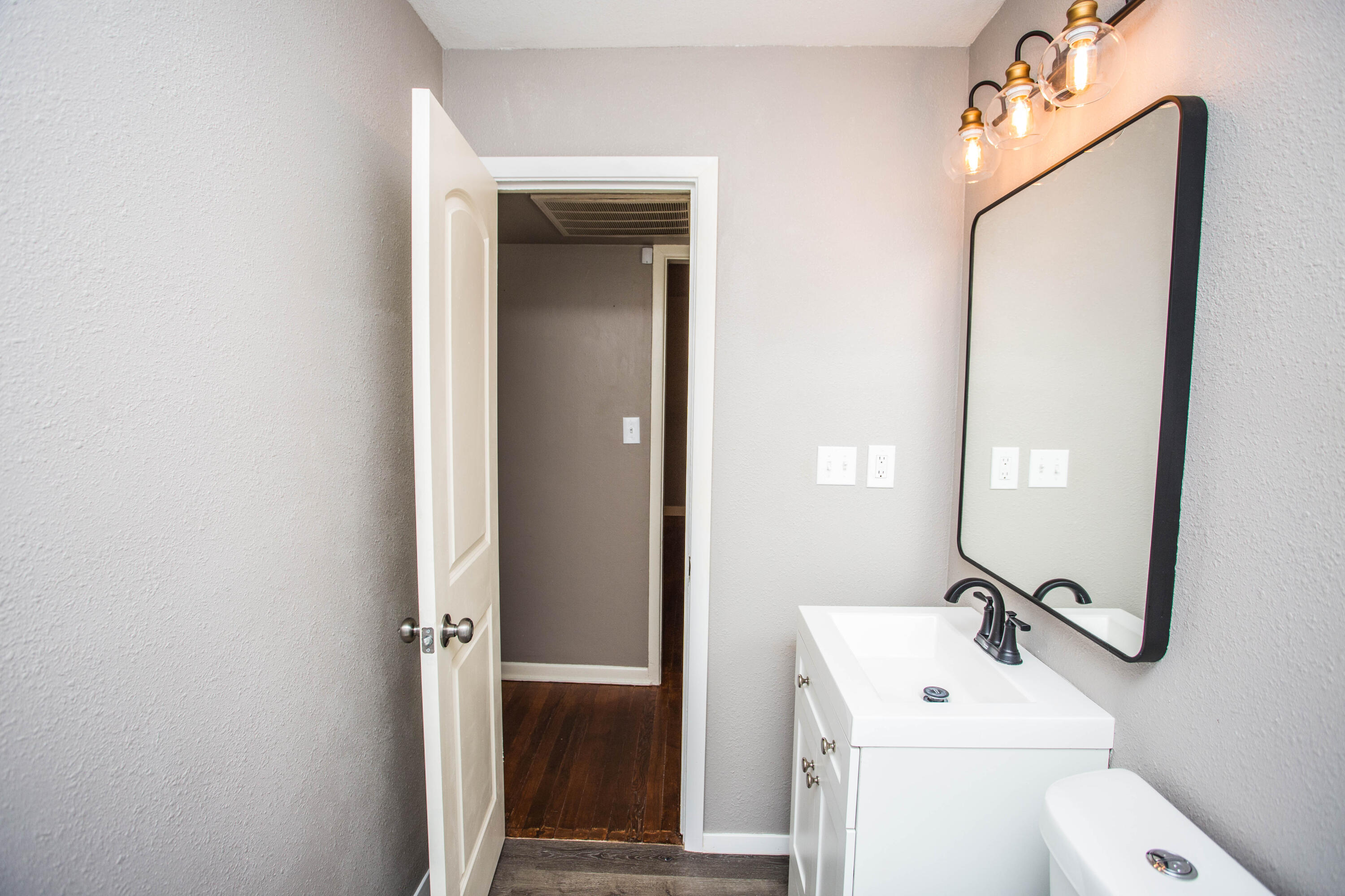 4402 29th Street, Unit B Lubbock, TX 79410 - Photo 18 of 23 a bathroom with a toilet a sink and mirror