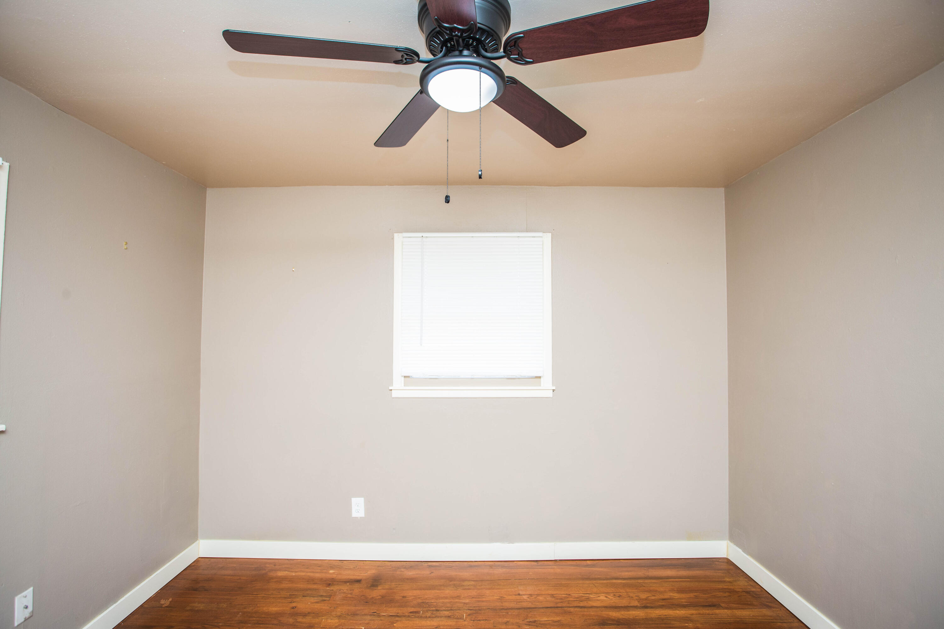 4402 29th Street, Unit B Lubbock, TX 79410 - Photo 19 of 23 an empty room with a window and a ceiling fan