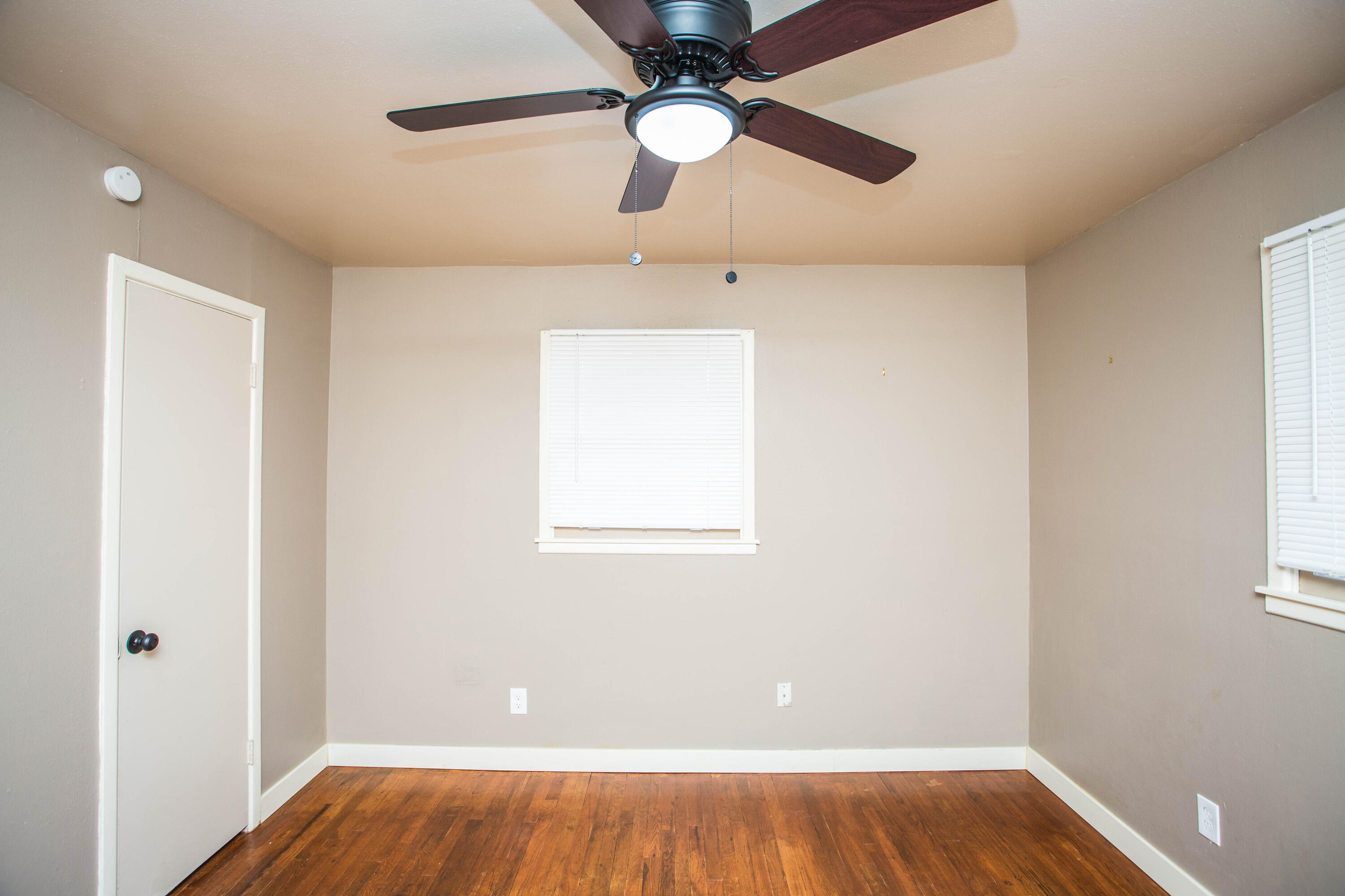 4402 29th Street, Unit B Lubbock, TX 79410 - Photo 20 of 23 wooden floor in an empty room with a window