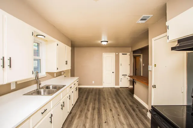 a view of empty room with wooden floor and ceiling fan