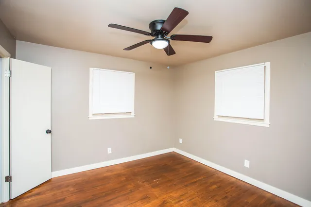 an empty room with a window and a ceiling fan