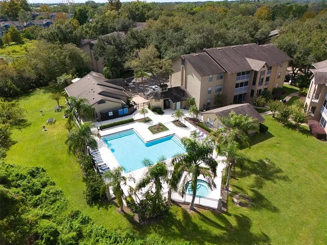 an aerial view of residential houses with outdoor space and trees
