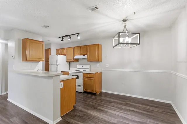 a kitchen with stainless steel appliances a stove top oven a sink a window and wooden floors