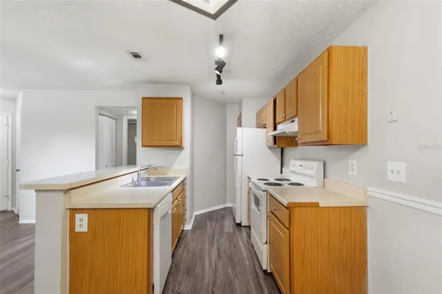 a kitchen with stainless steel appliances granite countertop a sink stove and cabinets