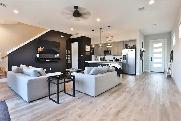 a living room with furniture and a wooden floor