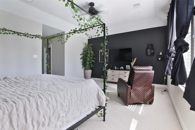 a bedroom with a large bed and a chandelier