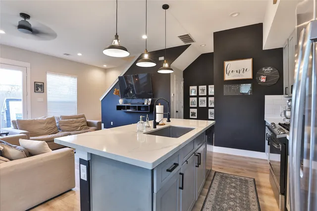 a kitchen with stainless steel appliances granite countertop a sink a refrigerator and a stove