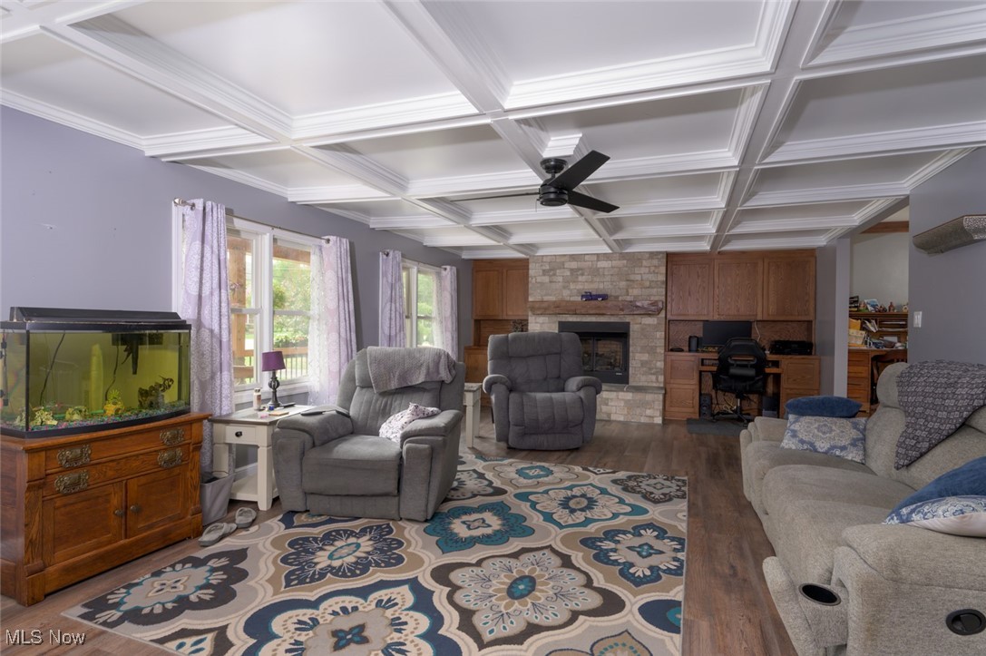 3234 Bell Wick Road Hubbard, OH 44425 - Photo 11 of 27 Living area with dark wood-style flooring, coffered ceiling, beamed ceiling, a fireplace, and ceiling fan