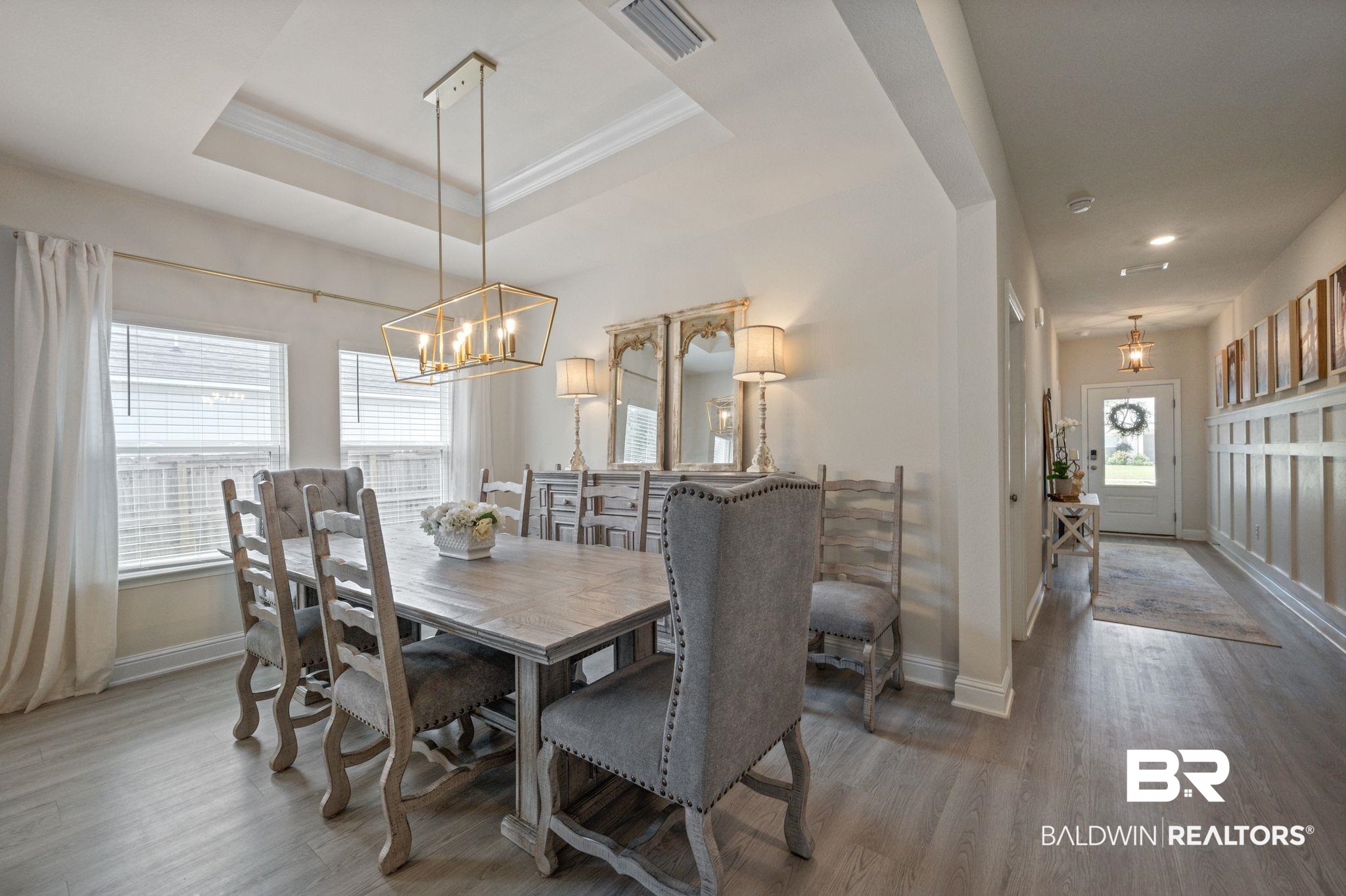 681 Calibre Street Fairhope, AL 36532 - Photo 15 of 56 Dining room featuring a tray ceiling, hardwood / wood-style flooring, and a chandelier