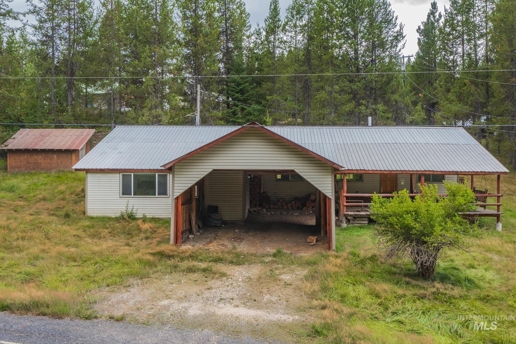 140 Ridgeway Drive Elk City, ID 83525 - Photo 11 of 47 View of front of house featuring a metal roof, a carport, driveway, and view of wooded area