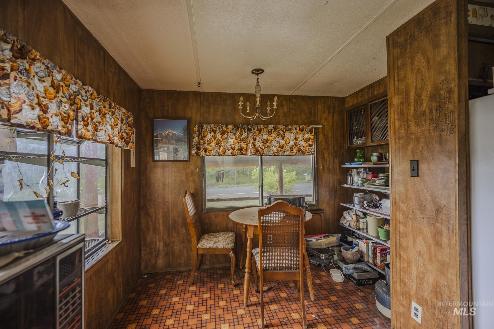 140 Ridgeway Drive Elk City, ID 83525 - Photo 15 of 47 Dining room with wood walls and a chandelier