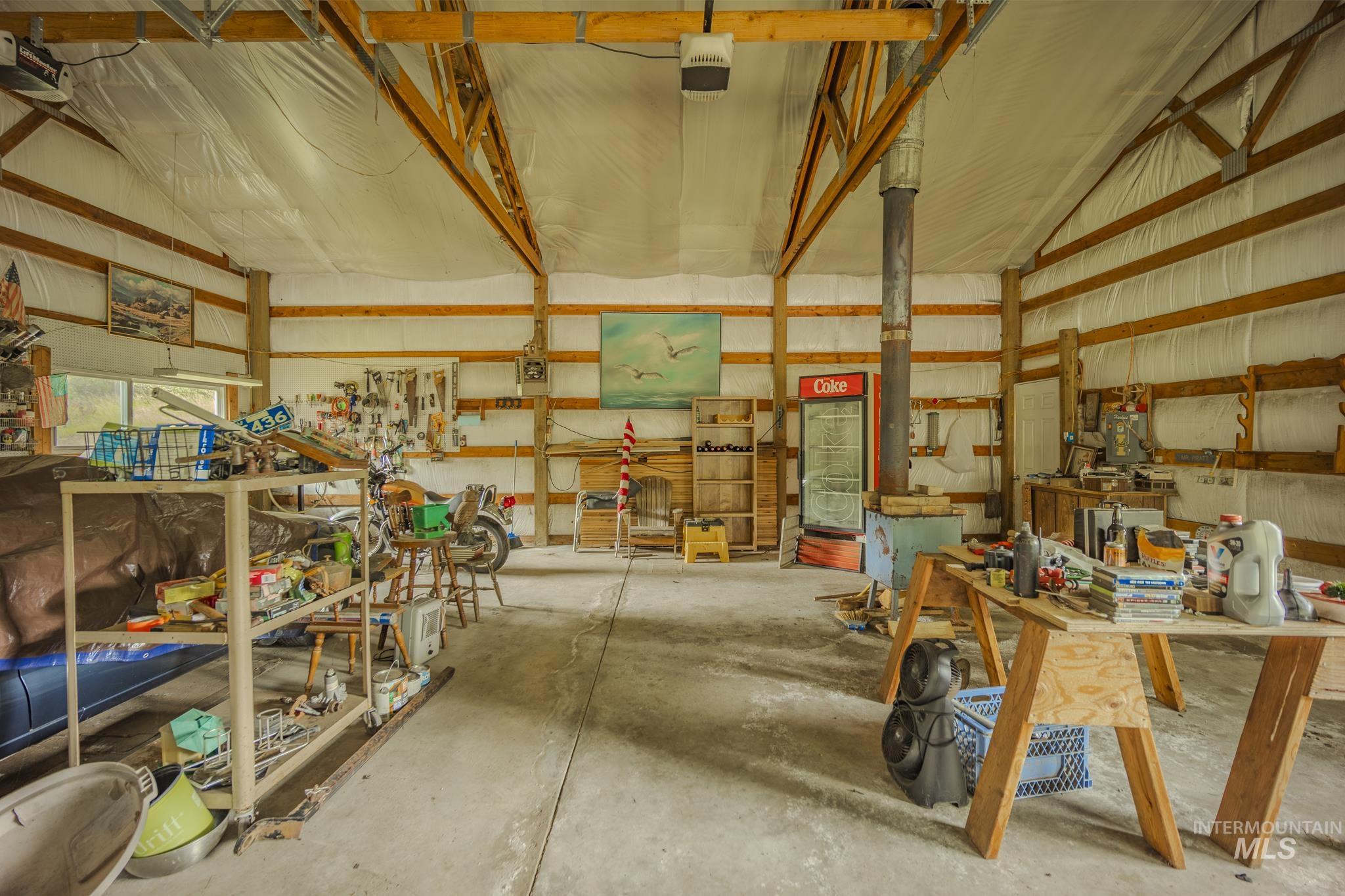 140 Ridgeway Drive Elk City, ID 83525 - Photo 39 of 47 Garage featuring a garage door opener, metal wall, and a workshop area
